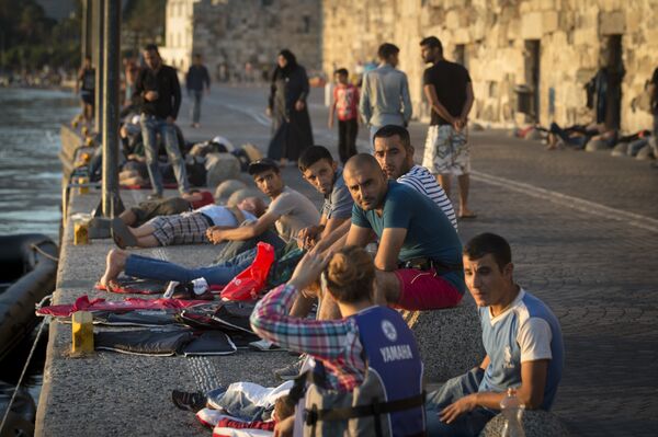 Migrants rest on an embankment of the port while waiting to be registered at the southeastern island of Kos, Greece, Wednesday, Aug. 19, 2015 Migrants rest on an embankment of the port while waiting to be registered at the southeastern island of Kos, Greece, Wednesday, Aug. 19, 2015 - Sputnik International