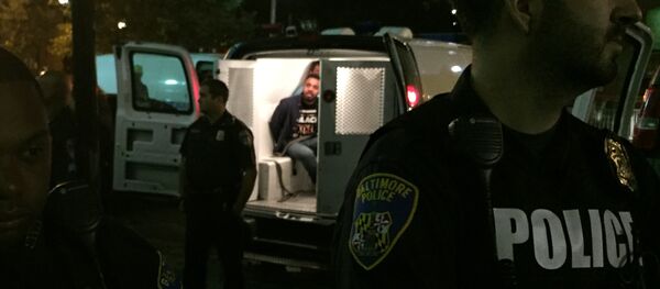 Police stand near vans holding protesters early Thursday, Oct. 15, 2015, in Baltimore - Sputnik International