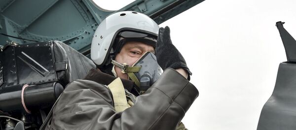 Ukrainian President Petro Poroshenko waves as he takes part in a testing flight onboard a Sukhoi Su-27 fighter aircraft during his working trip to Zaporizhia region on the Day of Defender of Ukraine, October 14, 2015 - Sputnik International
