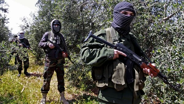 In this Friday, April 12, 2013 photo, members of the Lebanese pro-Syrian Popular Committees stand guard at the Lebanon-Syria border, near the northeastern Lebanese town of al-Qasr, Lebanon. Masked men in camouflage toting Kalashnikov rifles fan out through a dusty olive orchard. - Sputnik International