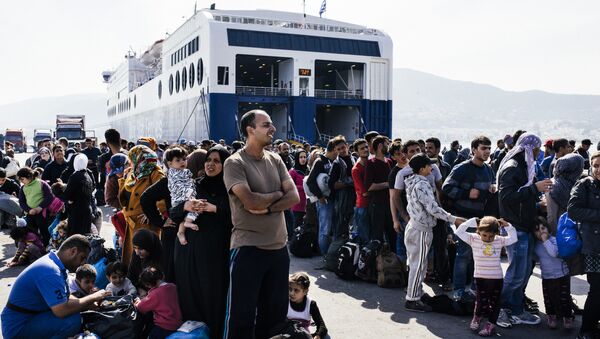 Refugees and migrants line up to board a ferry after arriving on the Greek island of Lesbos on October 16, 2015 - Sputnik International