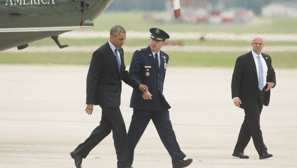 President Barack Obama talks with Col. Dave Siegrist, right, as they walk to Air Force One. - Sputnik International