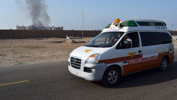 A picture taken on October 6, 2015 shows an ambulance driving as smoke billows from the Al-Qasr hotel in Aden. - Sputnik International