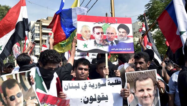 Syrians, living in Lebanon, carry banners as they wave Russian and Syrian national flags to express their support to Syria's President Bashar al-Assad and to thank Russia for its operation in Syria, outside the Russian embassy in Beirut, Lebanon, October 18, 2015 - Sputnik International
