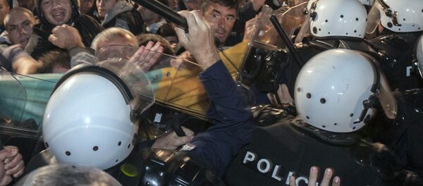 A riot policeman hits Montenegro's opposition leader Nebojsa Medojevic (facing camera, on R of baton) with a baton while dispersing protesters outside the parliament building in the capital Podgorica, Montenegro, October 17, 2015. - Sputnik International