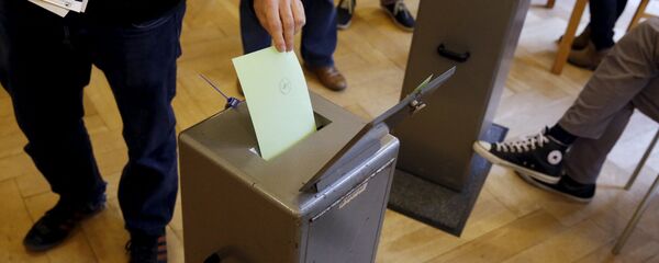 People cast their vote in a school house in Bern, Switzerland, October 18, 2015. People cast their vote in a school house in Bern, Switzerland, October 18, 2015. - Sputnik International