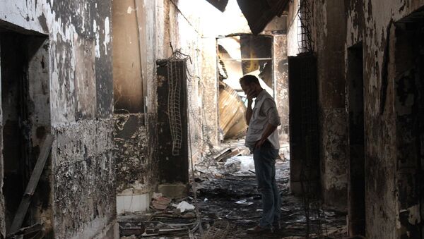 In this Friday, Oct. 16, 2015 photo, an employee of Doctors Without Borders walks inside the charred remains of their hospital after it was hit by a U.S. airstrike in Kunduz, Afghanistan. - Sputnik International