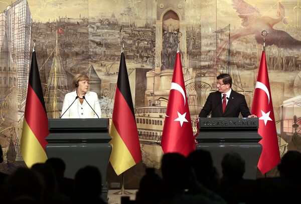 Turkish Prime Minister Ahmet Davutoglu, right, looks at Germany's Chancellor Angela Merkel, left, during a joint news conference after their meeting at his office in Dolmabahce Palace in Istanbul, Sunday, Oct. 18, 2015. - Sputnik International