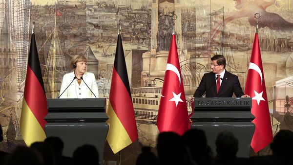 Turkish Prime Minister Ahmet Davutoglu, right, looks at Germany's Chancellor Angela Merkel, left, during a joint news conference after their meeting at his office in Dolmabahce Palace in Istanbul, Sunday, Oct. 18, 2015. - Sputnik International
