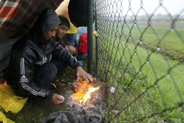 Migrants burn shoes in a bonfire to warm themselves up as they wait at the border with Slovenia in Trnovec, Croatia, October 19, 2015. - Sputnik International