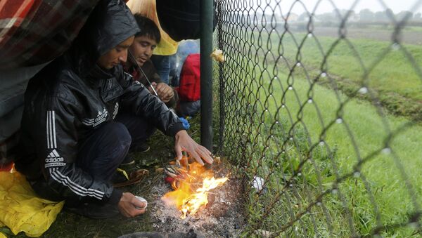 Migrants burn shoes in a bonfire to warm themselves up as they wait at the border with Slovenia in Trnovec, Croatia, October 19, 2015. - Sputnik International