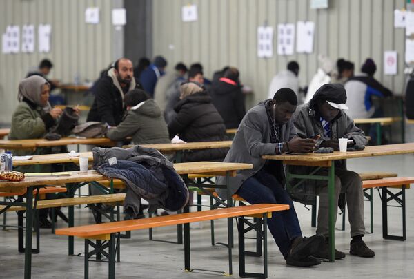 Migrants use their cell phones in a canteen in a refugee camp in Celle, Lower-Saxony, Germany October 15, 2015. Migrants use their cell phones in a canteen in a refugee camp in Celle, Lower-Saxony, Germany October 15, 2015. - Sputnik International