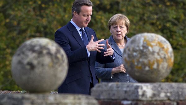 Britain's Prime Minister David Cameron (L) walks around the rose garden with German Chancellor Angela Merkel. - Sputnik International
