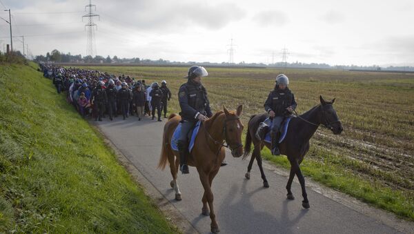 Policemen ride on their horses in front of migrants after they crossed from Croatia, in Dobova, near a border crossing between Croatia and Slovenia Tuesday, Oct. 20, 2015. - Sputnik International