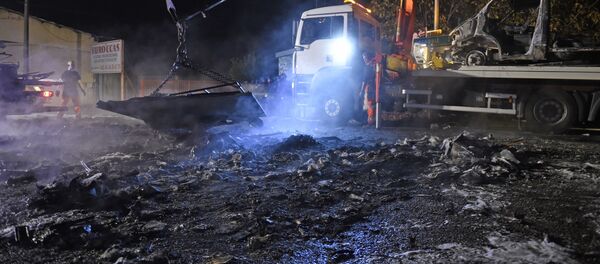 A man operates a crate, lifting up debris of burnt cars following a series of violent incidents on October 20, 2015 in Moirans, near Grenoble A man operates a crate, lifting up debris of burnt cars following a series of violent incidents on October 20, 2015 in Moirans, near Grenoble - Sputnik International