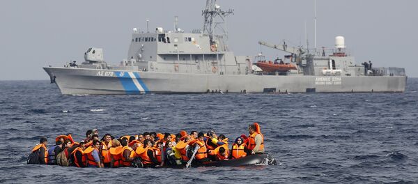 Syrian refugees call for help and empty water from their flooding raft as they approach the Greek island of Lesbos past a Greek coast guard vessel October 20, 2015 - Sputnik International