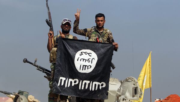 Iraqi Shiite fighters from the Popular Mobilisation units, fighting alongside Iraqi government forces, display, upside down, the flag of the Islamic State (IS) group during a military operation aimed at the centre of Baiji, some 200 kilometres north of Baghdad on October 19, 2015 - Sputnik International