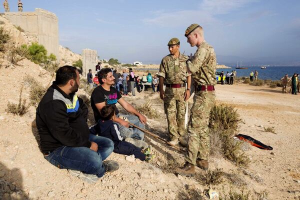 In this photo released by the British Forces in Cyprus on Wednesday, Oct. 21, 2015, British soldiers stand and talk with two of the 114 migrants at the British air forces in Akrotiri near southern coastal city of Limassol, Cyprus. In this photo released by the British Forces in Cyprus on Wednesday, Oct. 21, 2015, British soldiers stand and talk with two of the 114 migrants at the British air forces in Akrotiri near southern coastal city of Limassol, Cyprus. - Sputnik International