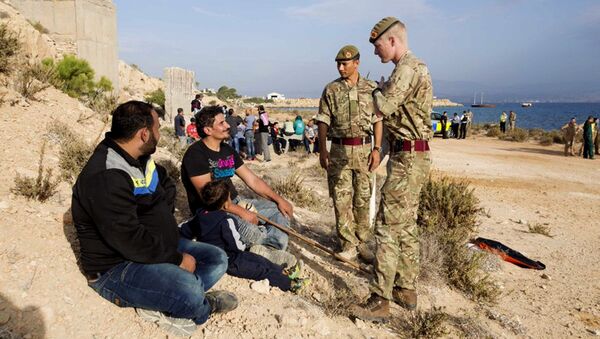 In this photo released by the British Forces in Cyprus on Wednesday, Oct. 21, 2015, British soldiers stand and talk with two of the 114 migrants at the British air forces in Akrotiri near southern coastal city of Limassol, Cyprus. - Sputnik International