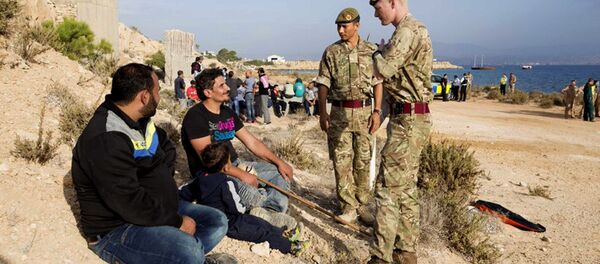 In this photo released by the British Forces in Cyprus on Wednesday, Oct. 21, 2015, British soldiers stand and talk with two of the 114 migrants at the British air forces in Akrotiri near southern coastal city of Limassol, Cyprus. - Sputnik International