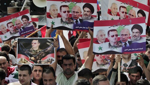 Syrians who lives in Lebanon hold posters with photos of Syrian President Bashar Assad, Russian President Vladimir Putin, Hezbollah leader Sheikh Hassan Nasrallah, and Lebanese Parliament Speaker Nabih Berri, with Arabic that reads Lions of the time, during a rally to thank Moscow for its intervention in Syria, in front of the Russian embassy in Beirut, Lebanon, Sunday, Oct. 18, 2015 - Sputnik International