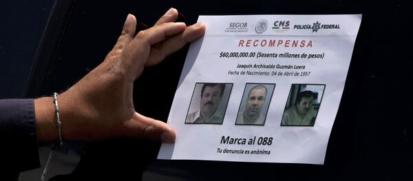 A Federal Police presses on a reward notice for information leading to the capture of drug lord Joaquin El Chapo Guzman, who made his escape from the Altiplano maximum security prison via an underground tunnel, in Almoloya, west of Mexico City, Thursday, July 16, 2015 - Sputnik International