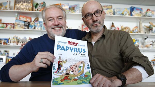 Author Jean-Yves Ferri (R) and illustrator Didier Conrad (L) pose with a print of the cover of their new comic book Le Papyrus de Cesar (Asterix and the Missing Scroll) in Vanves, Southern Paris, France, October 13, 2015 - Sputnik International