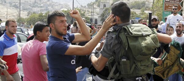 An Israeli border policeman exchanges blows with a Palestinian man during a confrontation after Friday prayers outside the Old City in Jerusalem Friday, Oct. 2, 2015 - Sputnik International