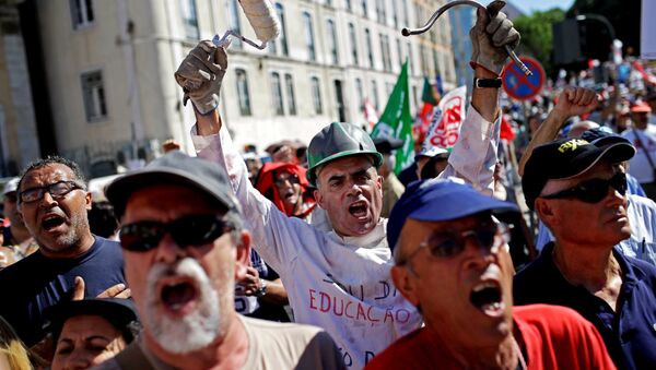 People shout slogans outside the Portuguese parliament during a protest by Portugal's main union CGTP, General Confederation of the Portuguese Workers, against cuts in salaries and pensions and others austerity measures taken by the government, in Lisbon, Thursday, July 10, 2014. - Sputnik International