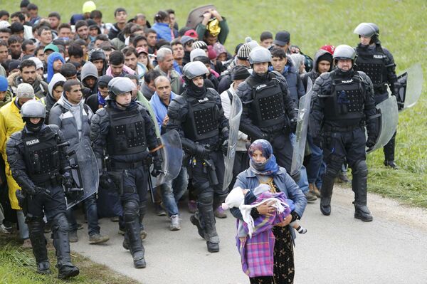 Police officers escort Fatima from Syria (front) and other migrants as they make their way on foot after crossing the Croatian-Slovenian border, in Rigonce, Slovenia, October 22, 2015 - Sputnik International