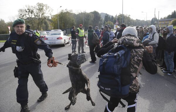 An Austrian policeman with a dog tries to maintain order after migrants left a camp on the border with Slovenia in Spielfeld, Austria, Thursday, Oct. 22, 2015 An Austrian policeman with a dog tries to maintain order after migrants left a camp on the border with Slovenia in Spielfeld, Austria, Thursday, Oct. 22, 2015 - Sputnik International