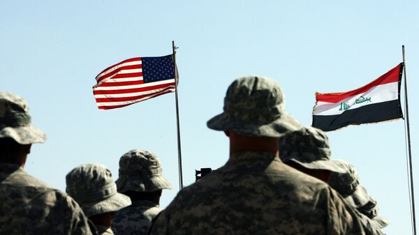 US troops stand to attention in front of American and Iraqi (R) flags during a handover ceremony near the northern Iraqi town of Hawija - Sputnik International