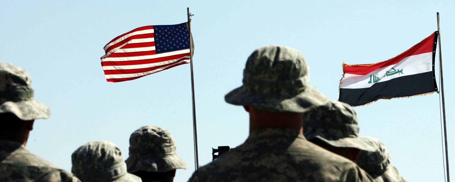 US troops stand to attention in front of American and Iraqi (R) flags during a handover ceremony near the northern Iraqi town of Hawija US troops stand to attention in front of American and Iraqi (R) flags during a handover ceremony near the northern Iraqi town of Hawija - Sputnik International, 1920, 19.12.2017