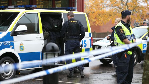 Police officers stand guard at a cordoned area after a masked man attacked people with a sword at a school in Trollhattan, western Sweden October 22, 2015 - Sputnik International