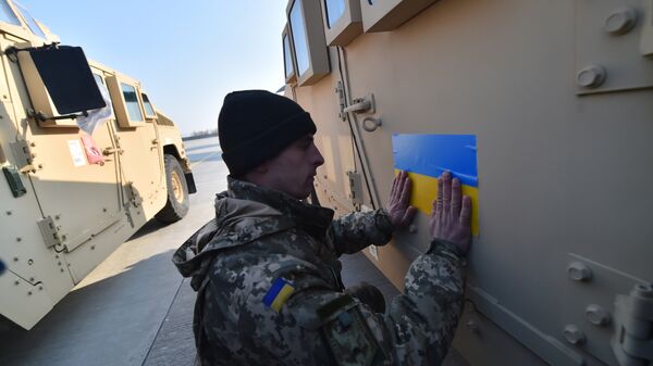 An Ukrainian serviceman sticks an Ukrainian flag on a Humvee at Kiev airport on March 25, 2015 during a welcoming ceremony of the first US plane delivery of non-lethal aid, including 10 Humvee vehicles - Sputnik International