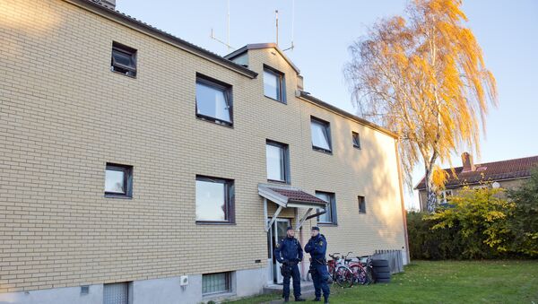 Police officers guard on October 23, 2015 the apartment building where the man who allegedely attacked students at a primary and middle school in Trollhattan, southwestern Sweden, used to live - Sputnik International