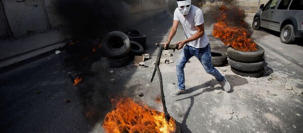 Palestinians burn tires front of Israel's separation barrier during clashes with Israeli troops for a tensions over a sensitive Jerusalem holy site, in the West Bank town of al-Ram, north of Jerusalem, Thursday, Oct. 22, 2015 Palestinians burn tires front of Israel's separation barrier during clashes with Israeli troops for a tensions over a sensitive Jerusalem holy site, in the West Bank town of al-Ram, north of Jerusalem, Thursday, Oct. 22, 2015 - Sputnik International