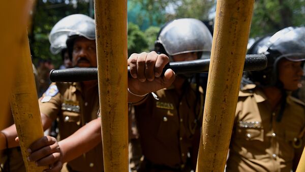 Sri Lankan police watch as Tamil protesters hold placards demanding the release of activists being held under tough anti-terror laws in the Sri Lankan capital Colombo on October 14, 2015 - Sputnik International
