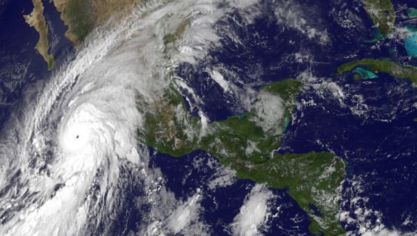 This satellite image taken at 10 a.m.. EDT on Friday, Oct. 23, 2015, and released by the National Oceanic and Atmospheric Administration shows Hurricane Patricia, left, moving over Mexico's Pacific Coast. - Sputnik International
