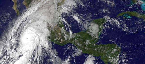 This satellite image taken at 10 a.m.. EDT on Friday, Oct. 23, 2015, and released by the National Oceanic and Atmospheric Administration shows Hurricane Patricia, left, moving over Mexico's Pacific Coast. - Sputnik International