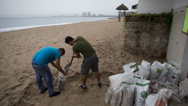 Men fill small bags with sand from the beach as they prepare for the arrival of Hurricane Patricia in Puerto Vallarta. - Sputnik International