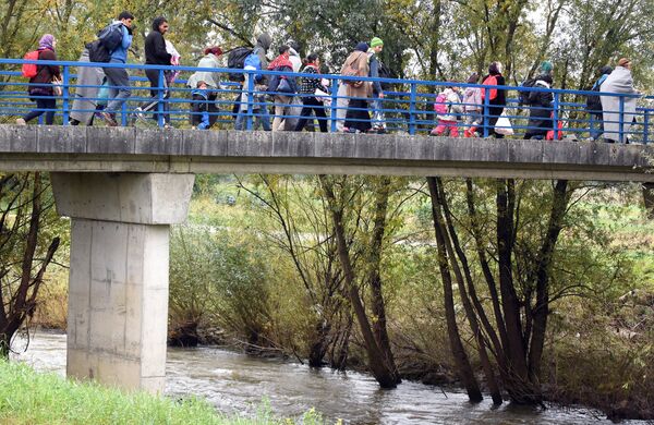Migrants cross the Sultla river at the Croatia-Slovenia border on October 23, 2015 near the border town of Kljuc Brdovecki, Croatia - Sputnik International