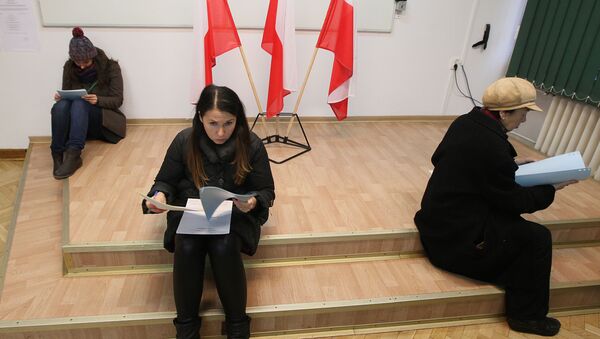 Voters read documents during the first round of Polish local elections in Warsaw, Poland, Sunday, Nov. 16, 2014 - Sputnik International