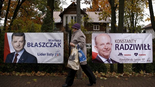A woman walks in front of the election posters of Law and Justice candidates Mariusz Blaszczak (L) and Konstanty Radziwill (R) in Milanowek, outskirts of Warsaw, Poland October 23, 2015. - Sputnik International