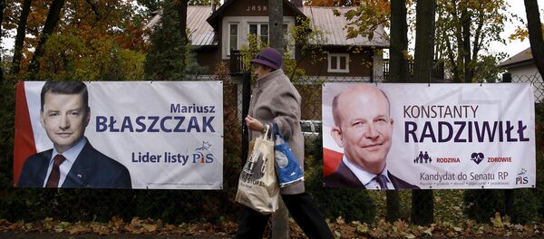 A woman walks in front of the election posters of Law and Justice candidates Mariusz Blaszczak (L) and Konstanty Radziwill (R) in Milanowek, outskirts of Warsaw, Poland October 23, 2015. A woman walks in front of the election posters of Law and Justice candidates Mariusz Blaszczak (L) and Konstanty Radziwill (R) in Milanowek, outskirts of Warsaw, Poland October 23, 2015. - Sputnik International