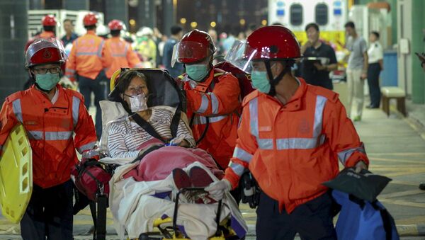 An injured ferry passenger is escorted by rescuers after getting onshore in Hong Kong, China October 25, 2015. - Sputnik International