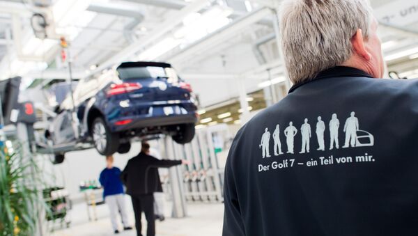 Employees of German car maker Volkswagen (VW) work on an electric car e-Golf at an assembly line at VW plant in Wolfsburg, central Germany, on October 21, 2015. - Sputnik International