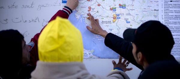 Migrants look at a map of the Western Balkans, in a registration camp, near Gevgelija on October 27, 2015. - Sputnik International