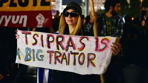 A woman holds a banner reading 'Tsipras is a big traitor', in front of the Greek parliament in Athens on October 16, 2015, while Greece's parliament is expected to approve later a first batch of reforms and tax cuts stemming from its third EU bailout. - Sputnik International