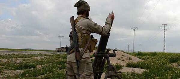 In this photo released on March 23, 2015, by a militant website, which has been verified and is consistent with other AP reporting, an Islamic State militant fires a mortar against Kurdish fighters, at the frontline near Tel Abyad town, northeast Syria - Sputnik International